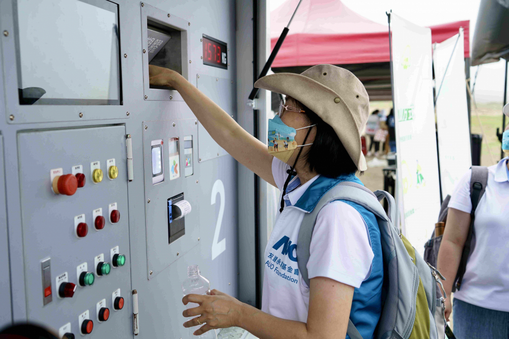 志工們將拾起的寶特瓶投入「好歸塑專車」，讓廢棄塑料空瓶可以直接粉碎、縮小體積，未來將可再製成購物袋、寶特衣、悠遊卡等生活用品